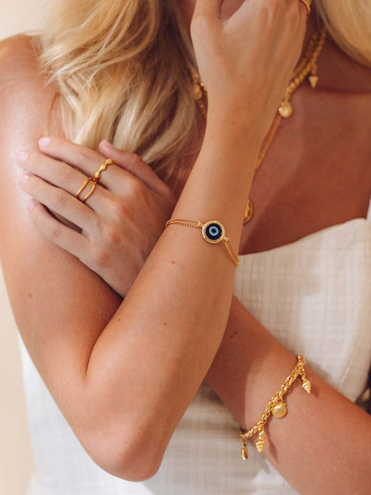 Close-up of a person wearing gold jewelry with a white background