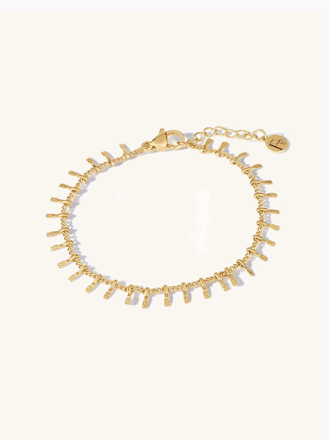 Gold bracelet with textural bars on a white background