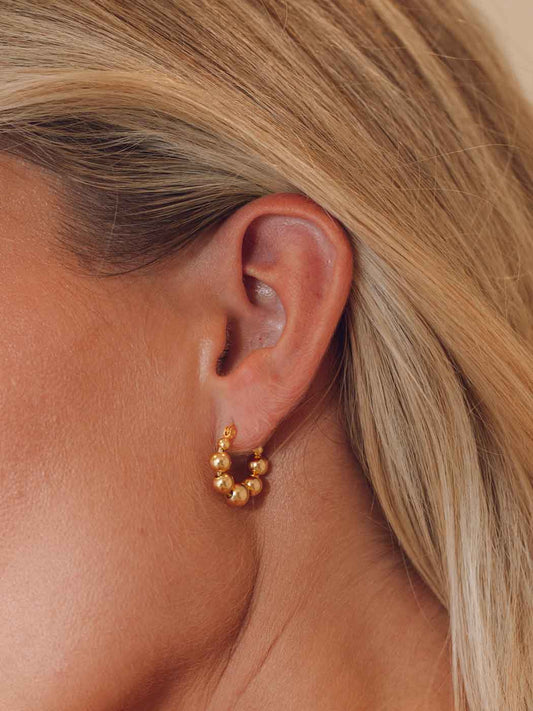 gold bubble shaped hoops on blonde model