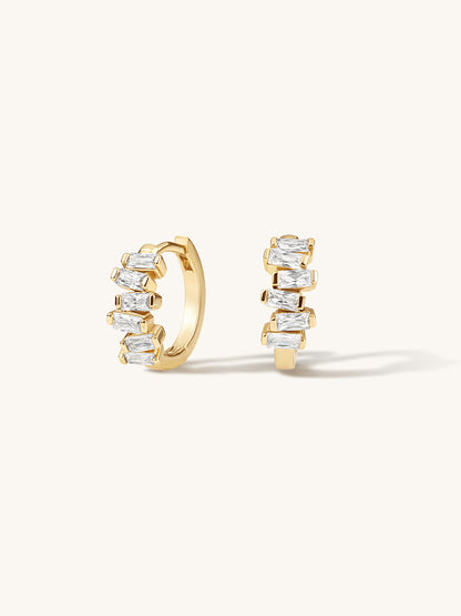 Gold hoop earrings with clear gemstones on a white background