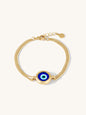 Gold bracelet with a blue evil eye charm on a white background