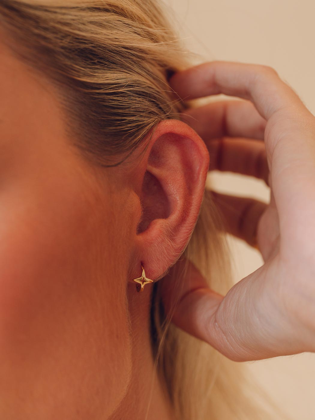 gold single star huggies on close up of ear