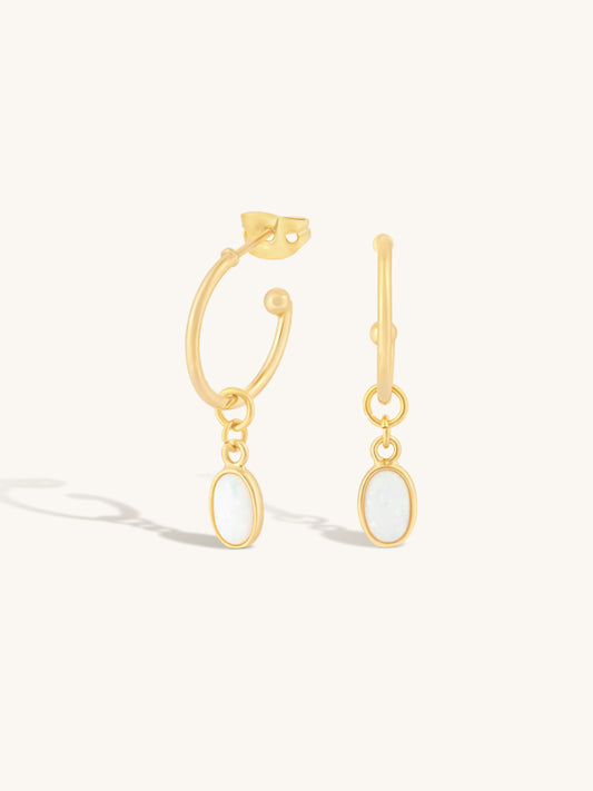 delicate gold hoops with oval shaped opal pendant attached