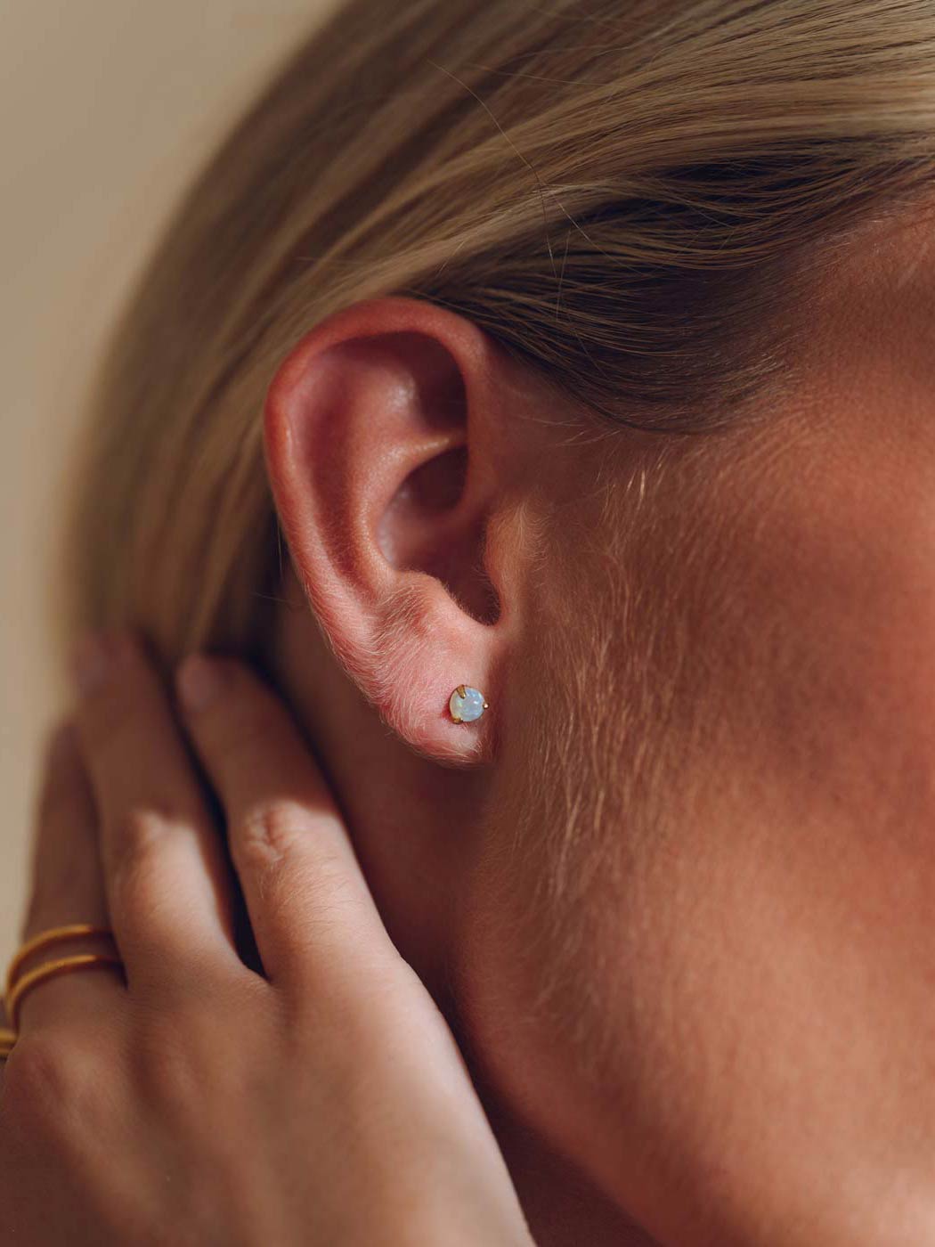 Close-up of an ear with a small round opal stud