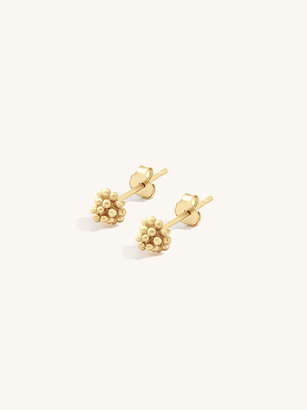 Pair of gold beaded stud earrings on a white background