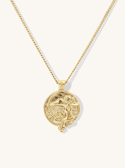 A gold chain necklace featuring a circular pendant with agoddess artemis figure, displayed against a clean off-white background.