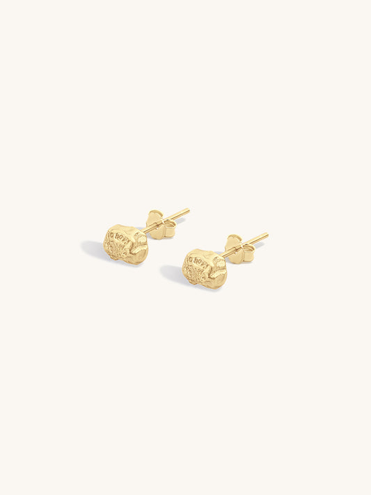 Pair of gold textured nugget earrings on a light gray background