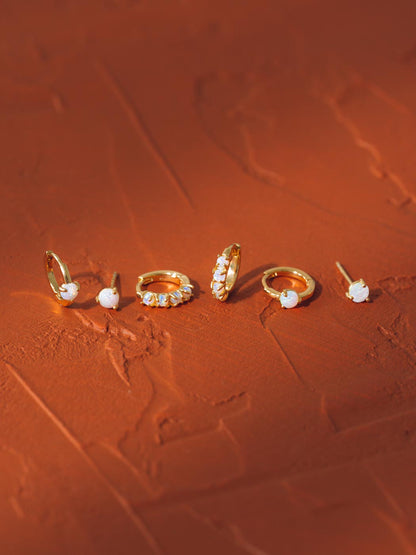 range of opal huggies and studs on deep orange background
