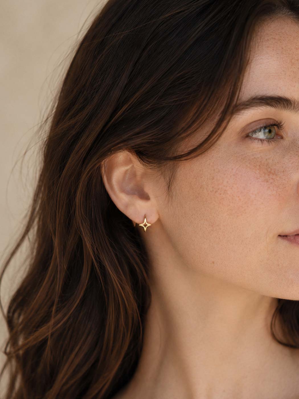 gold single star huggies on ear angled